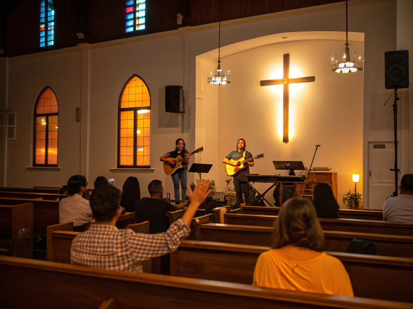 Acoustic worship team playing guitar in gentle warm stage lighting